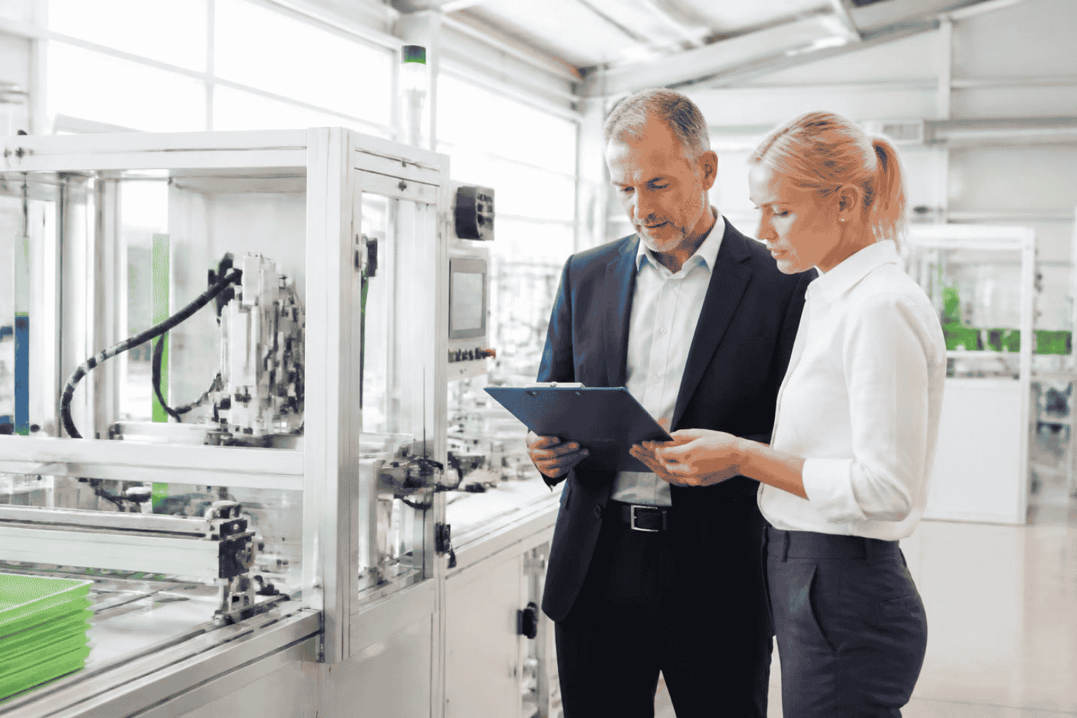Business owner reviewing automation equipment funding beside modern machinery