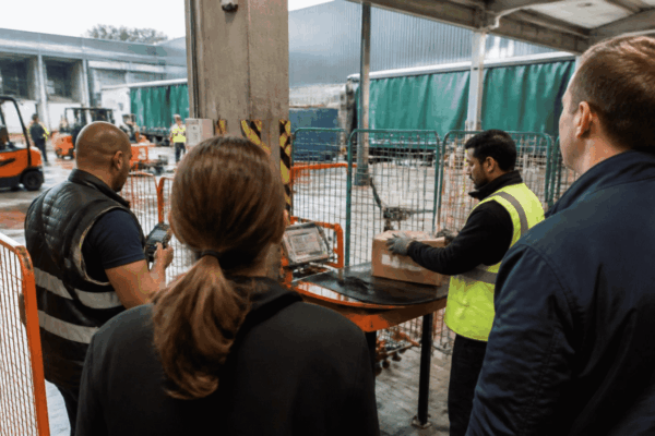 Startup founder observing an enterprise technology pilot at a logistics facility