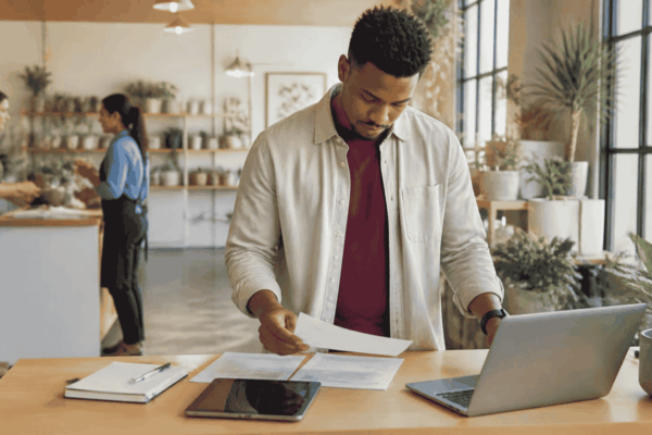 Young business owner reviewing revenue and bank deposits while exploring funding options